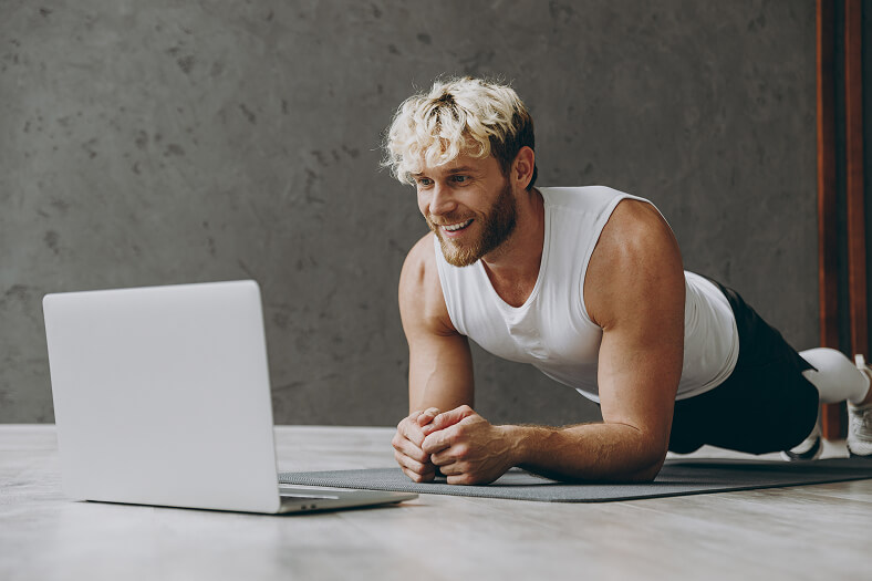 Man Doing Plank in Front of Laptop Computer